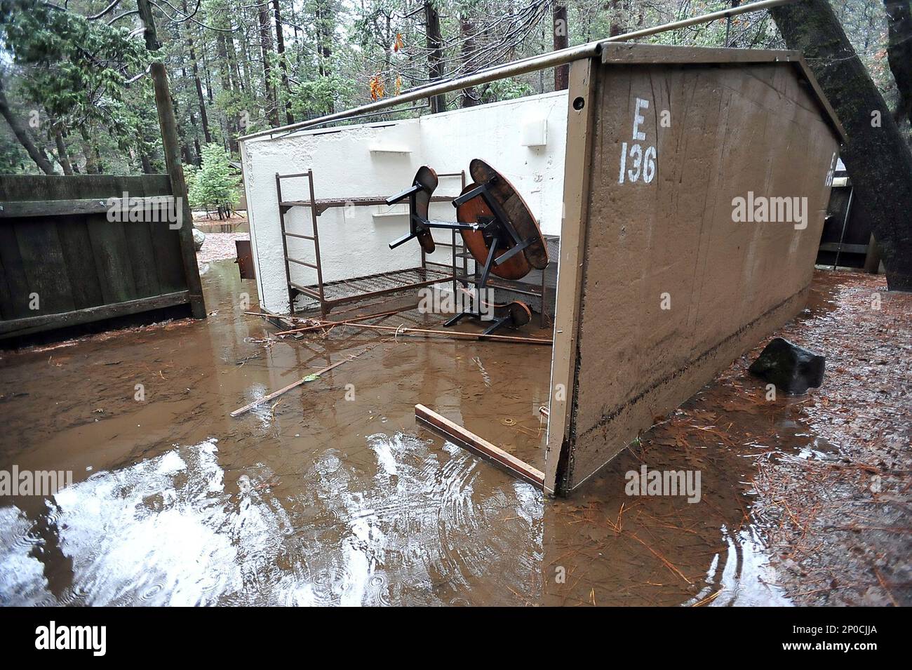 The back patio area of cabin is partially submerged in flood water at