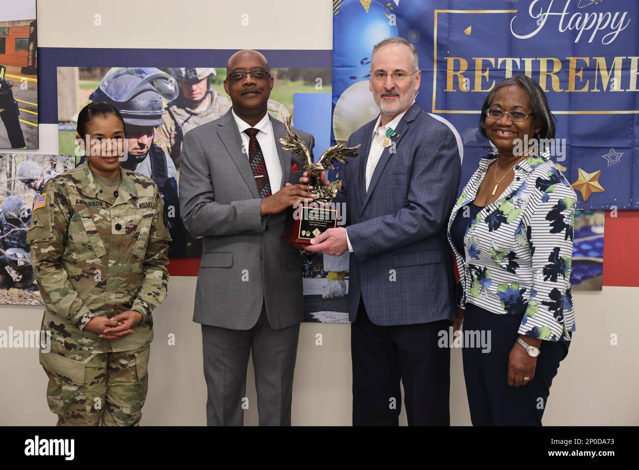 Lt. Col. Anne S. Anderson (left), the Assistant Chief of Staff for Communications (G6), and Monte Dashiell (second from left), the deputy G6, present a trophy to Michael R. Williams and his wife Elaine Williams.  Michael Williams retired after 41 years of uniformed and civil service on Aberdeen Proving Ground, Maryland, Feb. 22.  U.S. Army photo by Angel D. Martinez-Navedo. Stock Photo