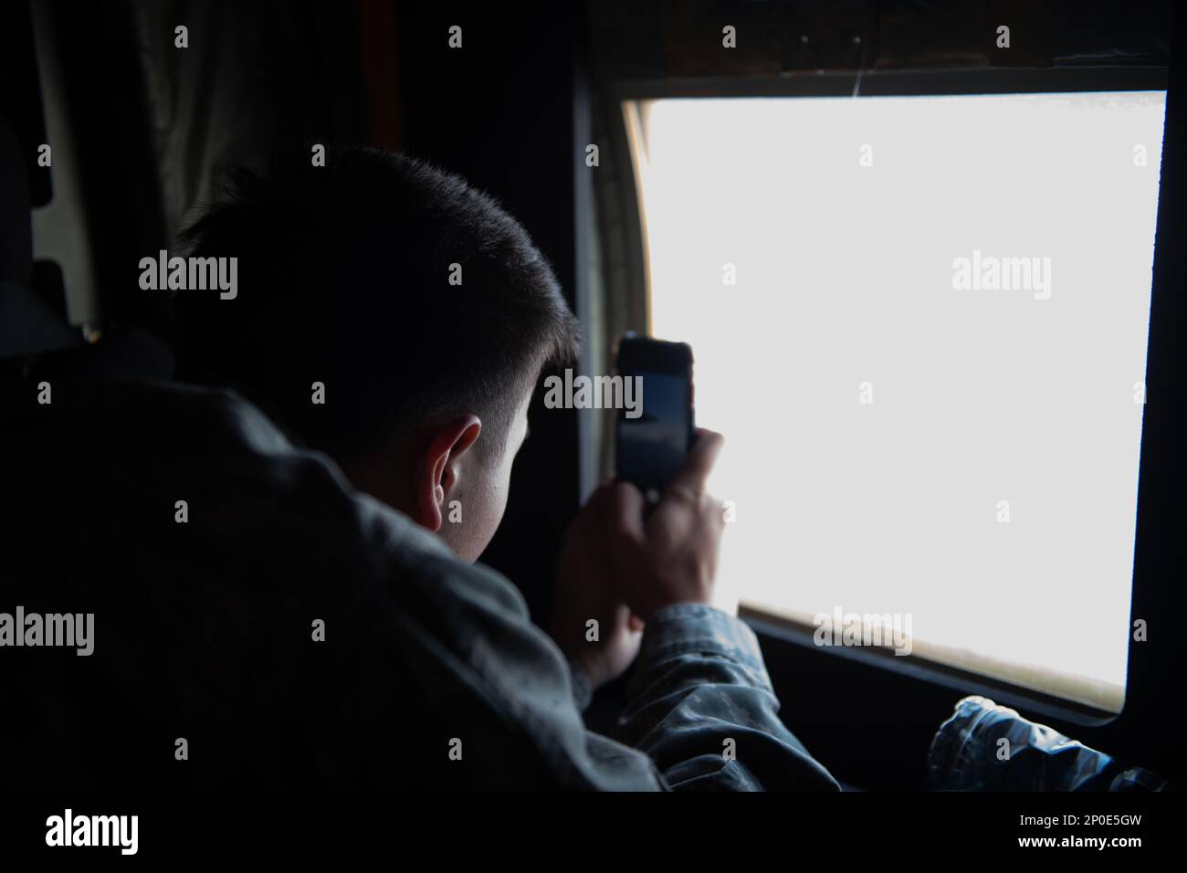 A student from Kadena High School’s Junior Reserve Officer Training Corps takes a photo out of the window of an MC-130J Commando II aircraft during an incentive flight at Kadena Air Base, Japan, Jan. 20, 2023. The students were taking part in the flight as a part of their JROTC course. Stock Photo