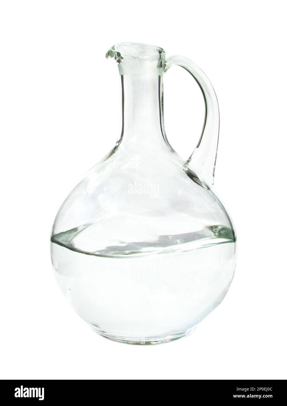 Glass pitcher with a handle halffull of water, isolated on white