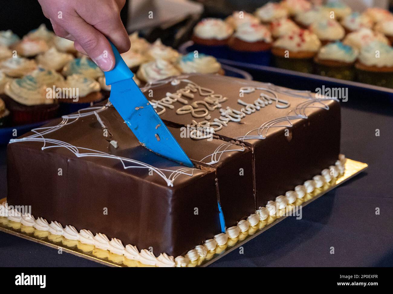 A cake is cut for USO Saudi Arabia's 82nd birthday party at Prince Sultan Air Base, Saudia Arabia, Feb. 4, 2023. The celebration included cake, balloons, raffle prizes and camaraderie. The USO has been serving U.S. military service members by keeping them connected to family, home and country since 1941. Stock Photo