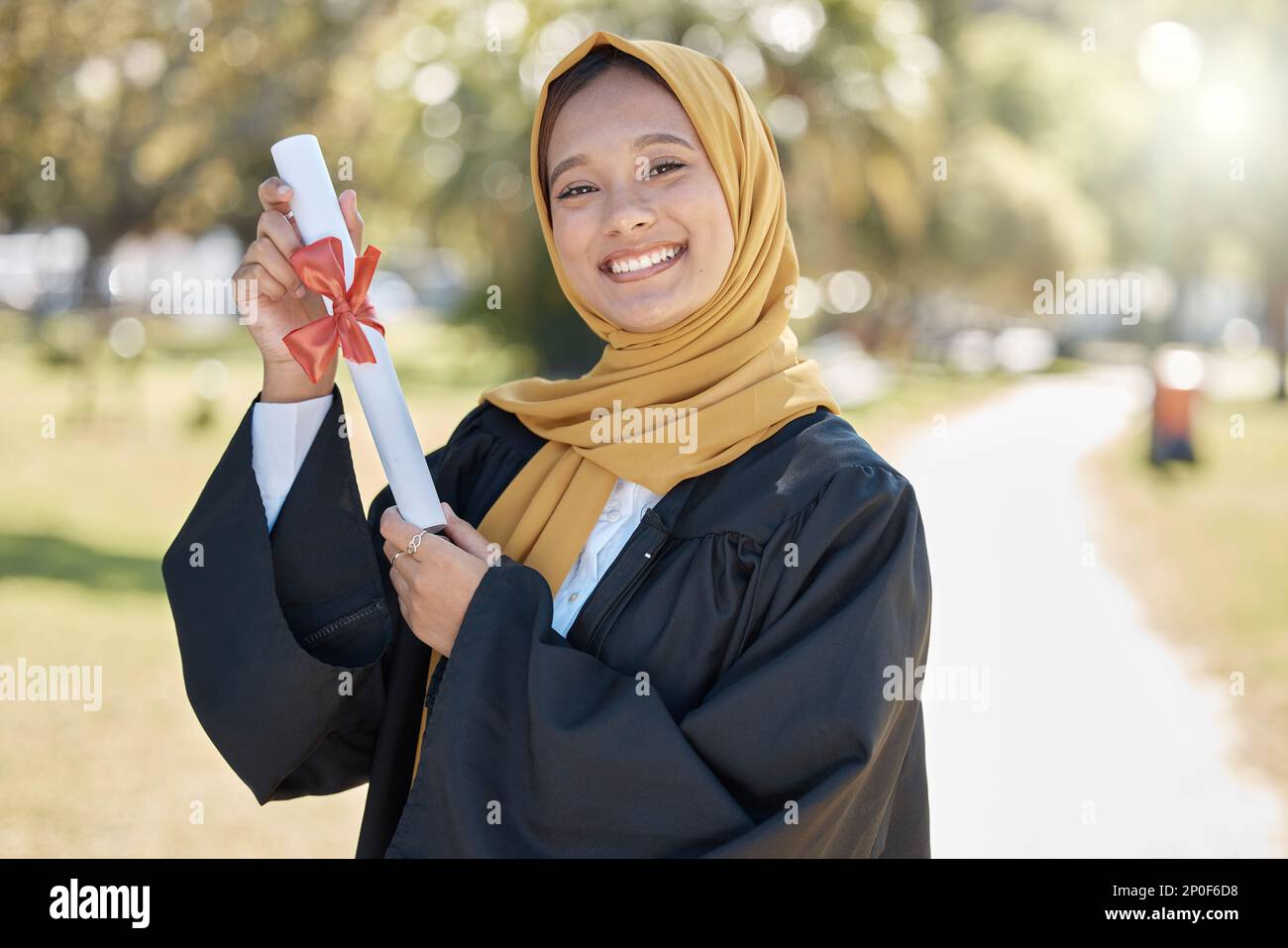 Graduation portrait, university and muslim woman with certificate for education, learning success and college. Islamic student or young hijab person Stock Photo