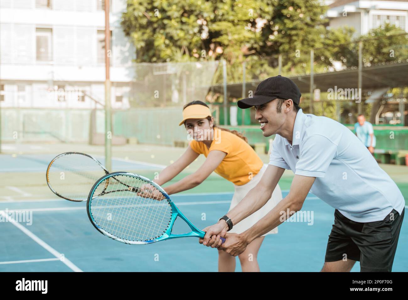 female tennis player holding a racket following the coach's movements ...