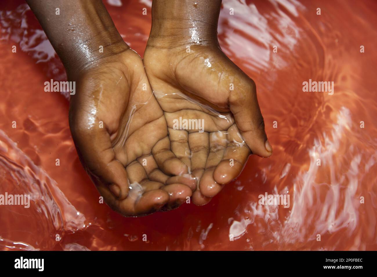 Children wash their hands in fresh, clean water from a well, Rwanda Stock Photo