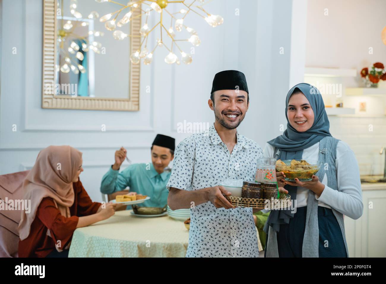husband and wife serving food for friend for break fasting Stock Photo