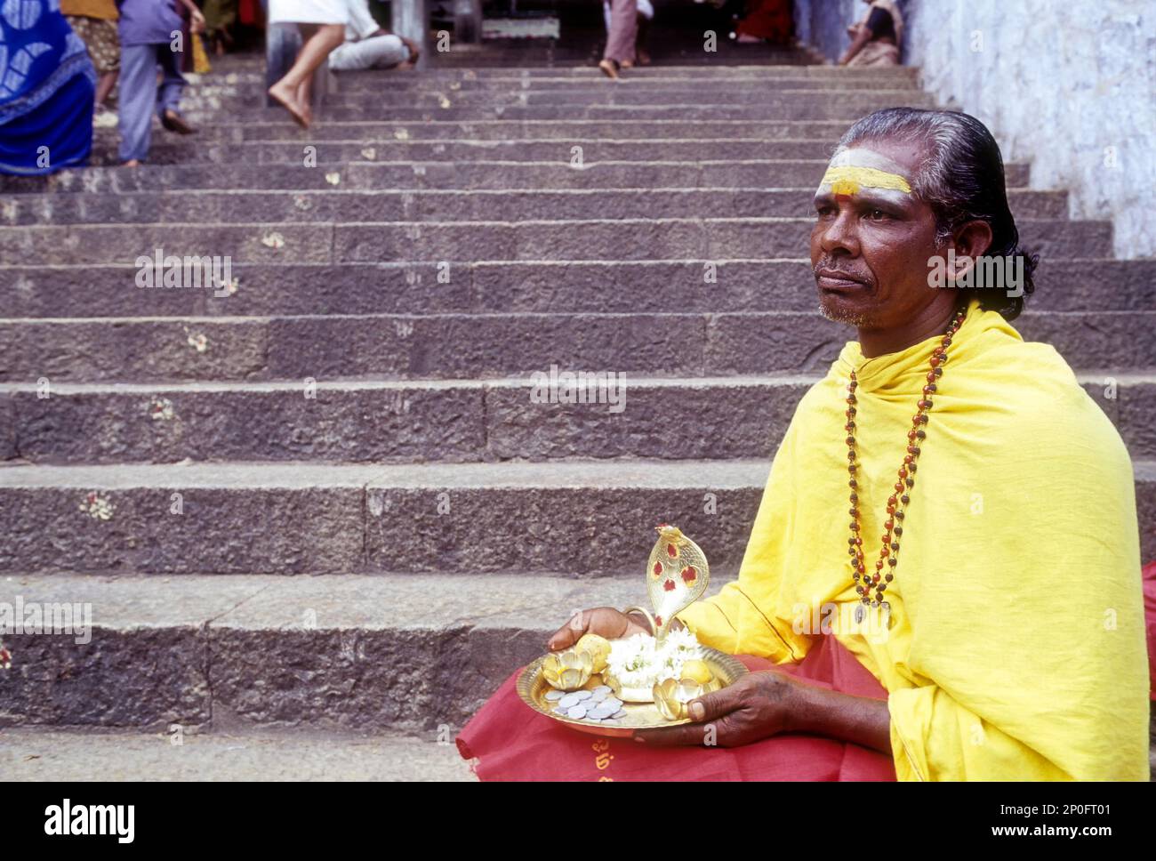 Elderly male Hindu beggar sitting on the steps of Dhandayuthapani temple at Palani near Coimbatore, Tamil Nadu, India Stock Photo