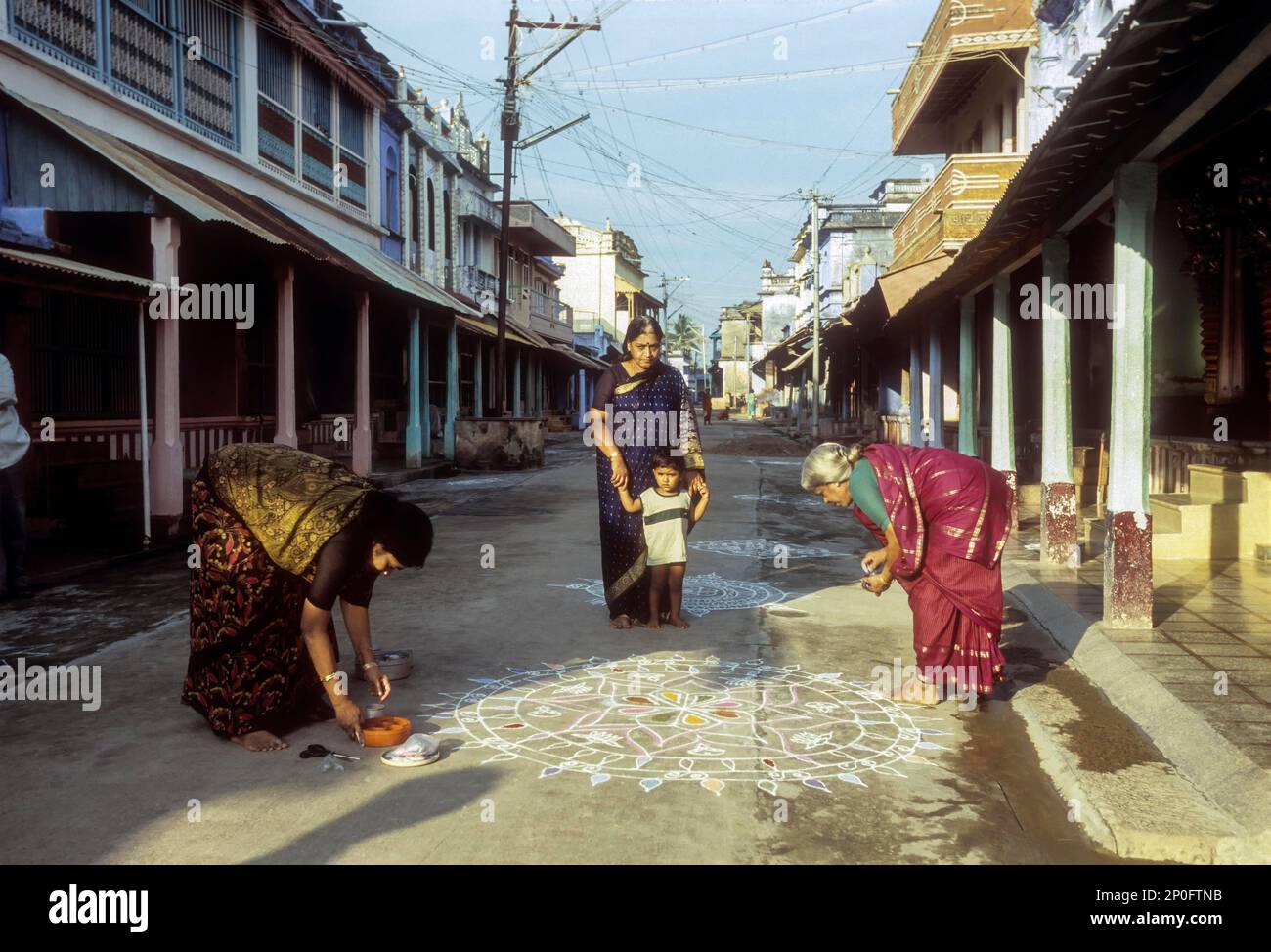Brahmin women drawing a kolam at Sundarapandyapuram, Agraharam, Tamil