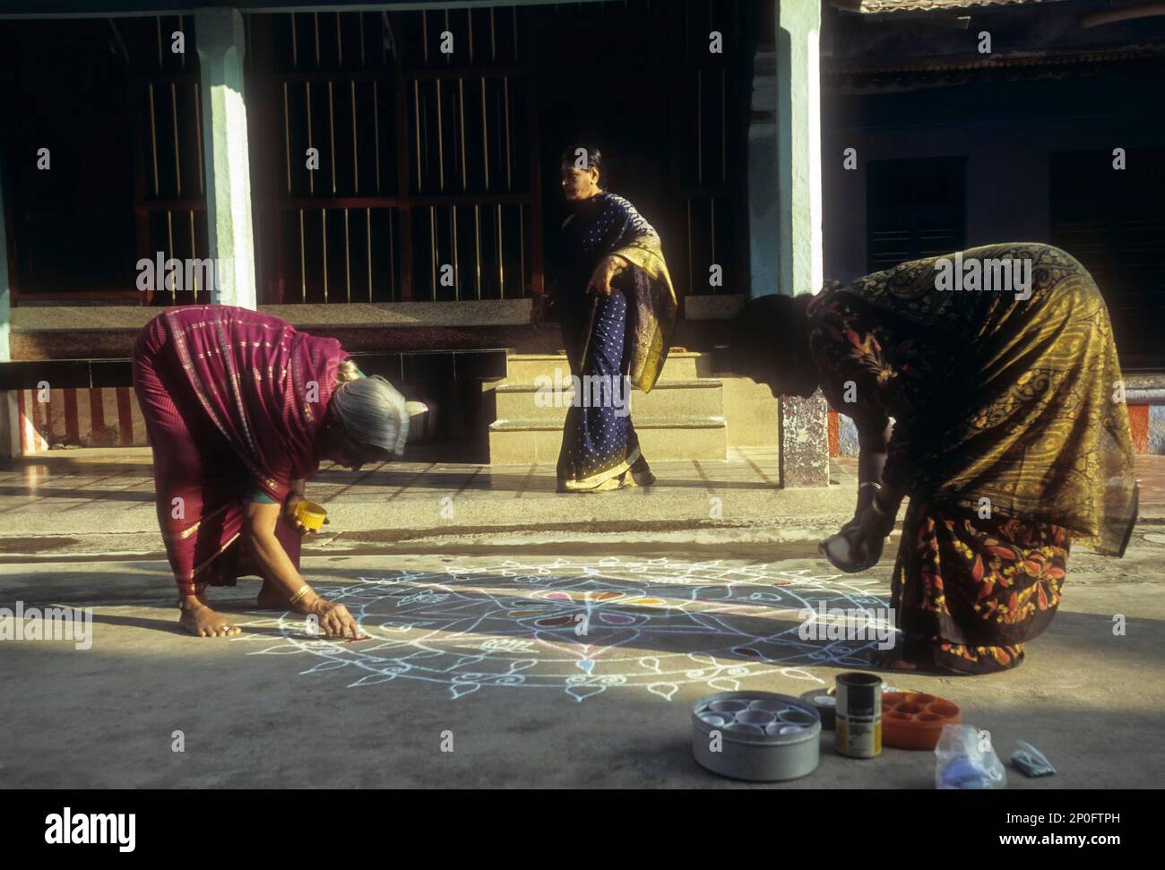 Brahmin women drawing a kolam at Sundarapandyapuram, Agraharam, Tamil
