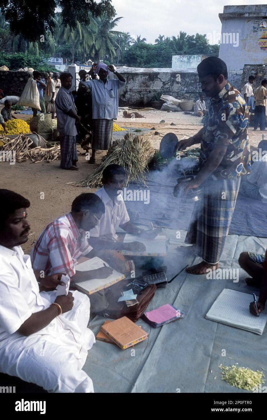 Applying sambrani, (benzoin) resin fumes to the shop at Thovalai flower