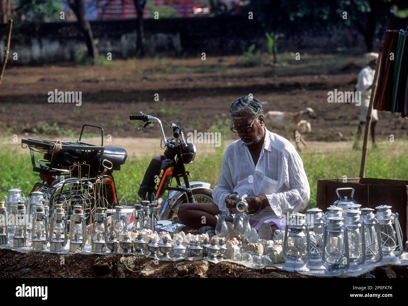 A old man cleaning hurricane lamps periodical market, Tamil Nadu, India