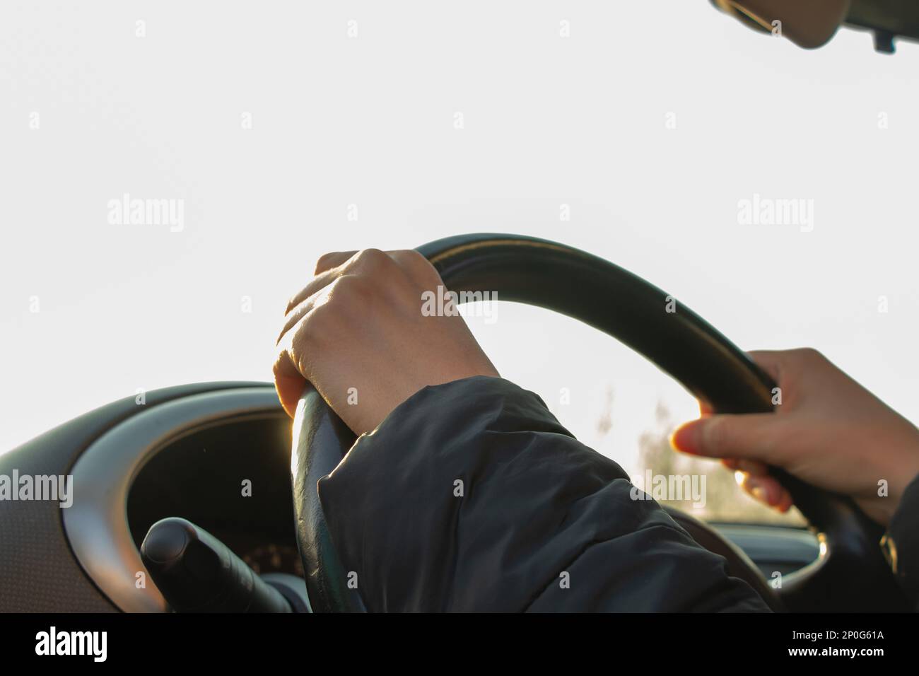 hands on the steering wheel inside the car in the afternoon Stock Photo