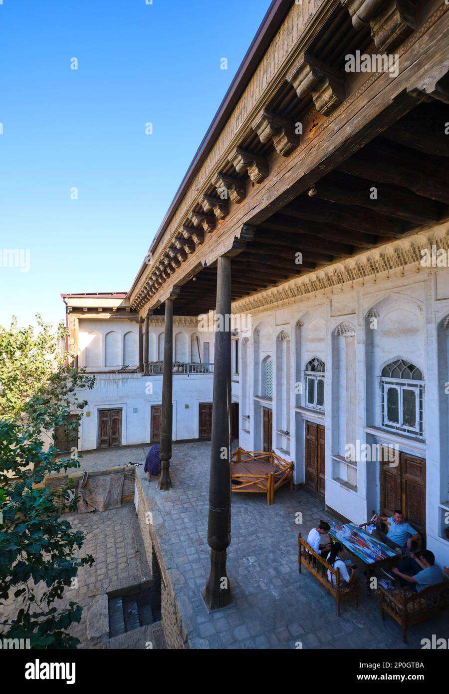 Double height porch, veranda with carved wood columns. At an old, historic, classic, traditional, typical, iconic Jewish house in Bukhara, Uzbekistan, Stock Photo