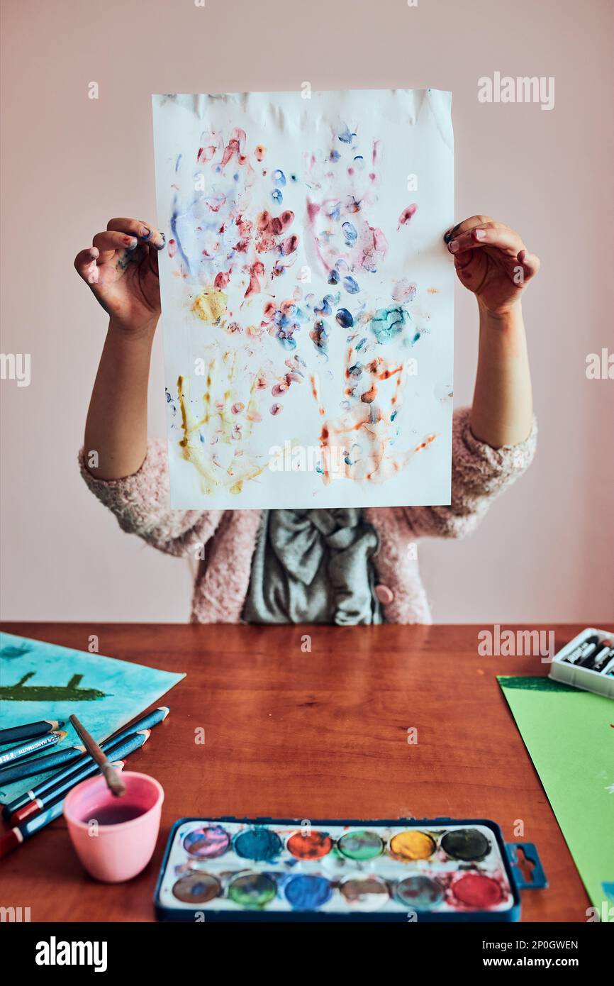 Little girl preschooler painting a picture using colorful paints and ...