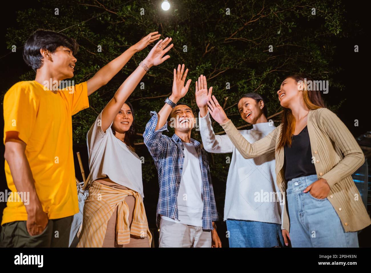 a group of people raise their hands after a high fived Stock Photo - Alamy