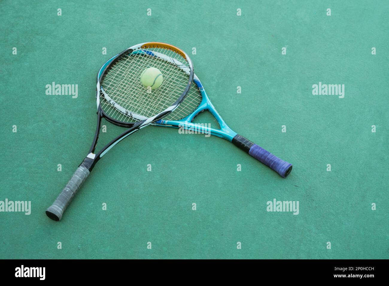 tennis rackets and balls piled on the green court floor Stock Photo Alamy