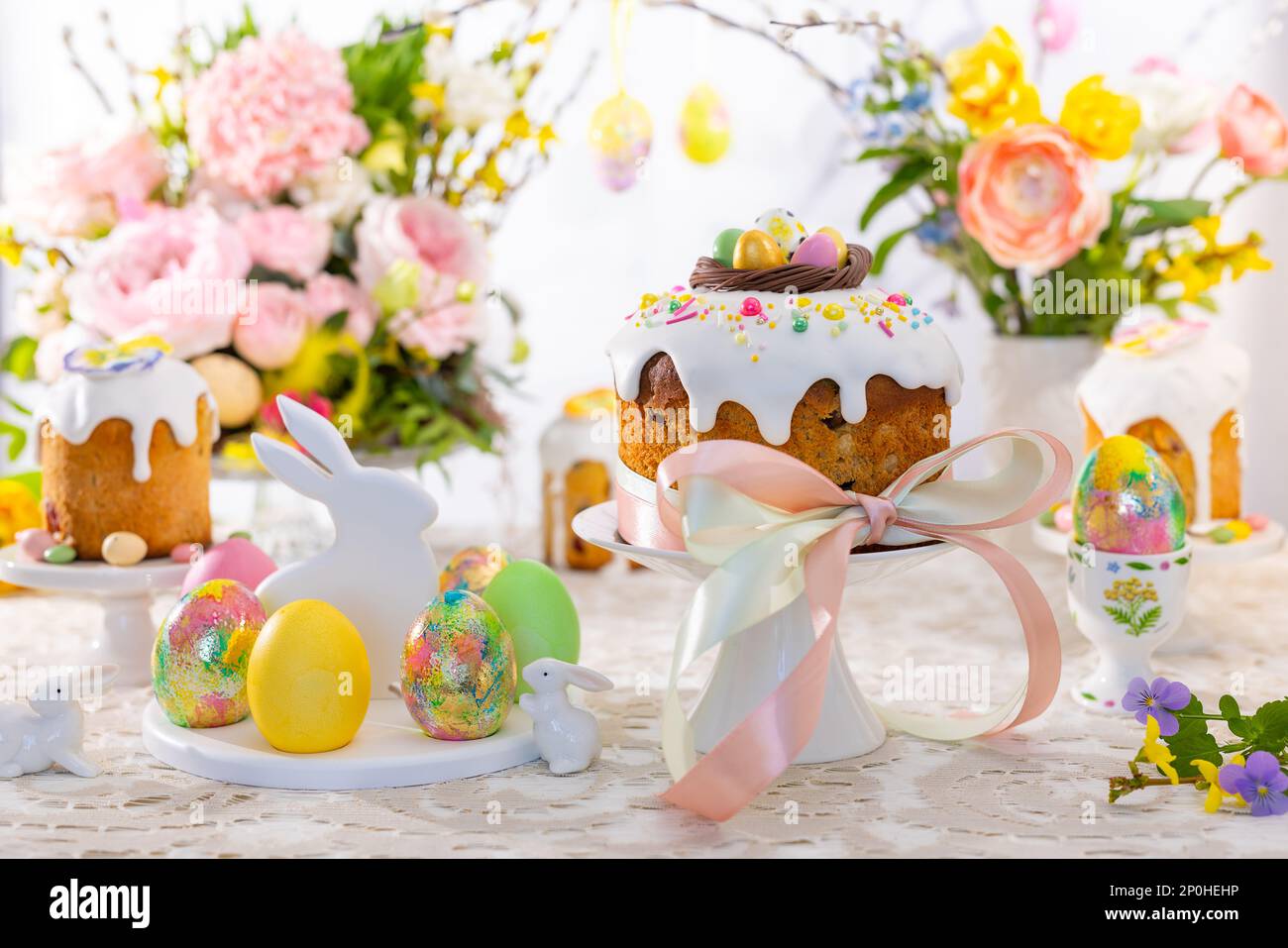 Festive Easter table setting. Easter cake, Easter Eggs, Flower arrangements and home decorations for holiday. Stock Photo