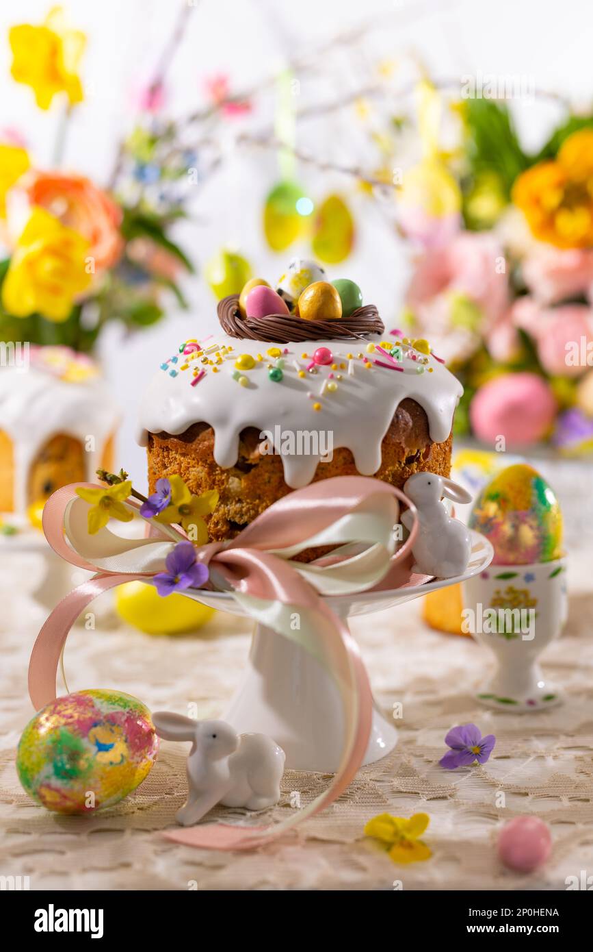 Festive Easter table setting. Easter cake, Easter Eggs, Flower arrangements and home decorations for holiday. Stock Photo