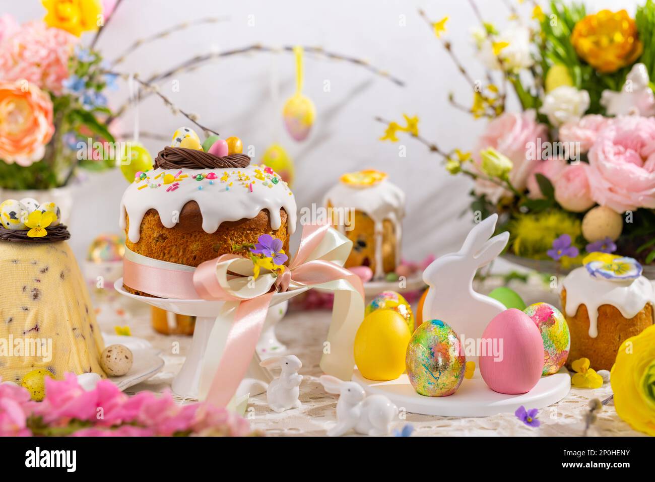 Festive Easter table setting. Easter cake, Easter Eggs, Flower arrangements and home decorations for holiday. Stock Photo