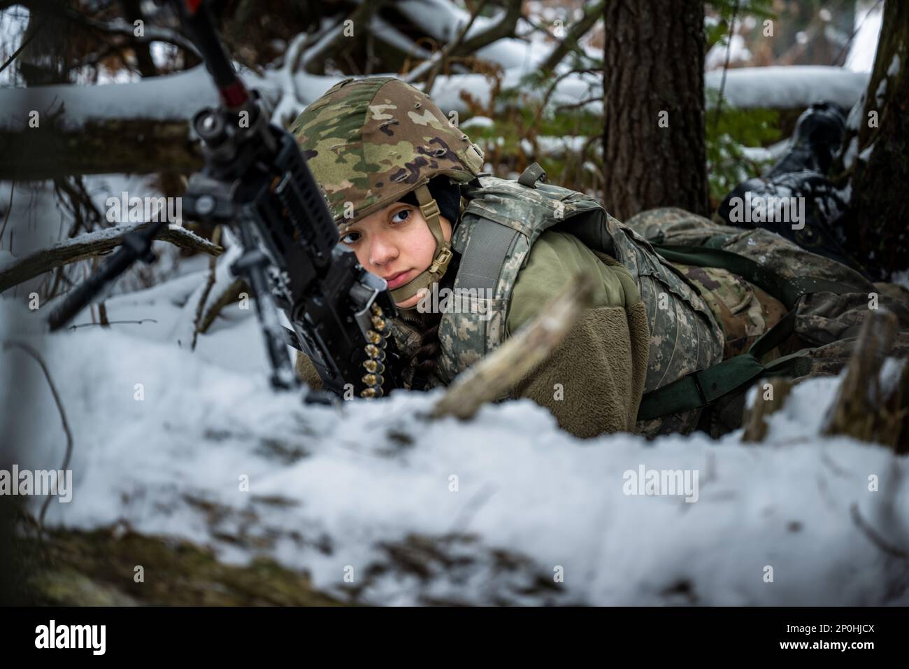 Army Pvt. Ashley Rodriguez, 1-120th Field Artillery Regiment, provides security with the M240 machine gun as the gun team sets up an M119 howitzer during Northern Strike 23-1, Jan. 25, 2023, at Camp Grayling, Mich. Units that participate in Northern Strike’s winter iteration build readiness by conducting joint, cold-weather training designed to meet objectives of the Department of Defense’s Arctic Strategy. Stock Photo