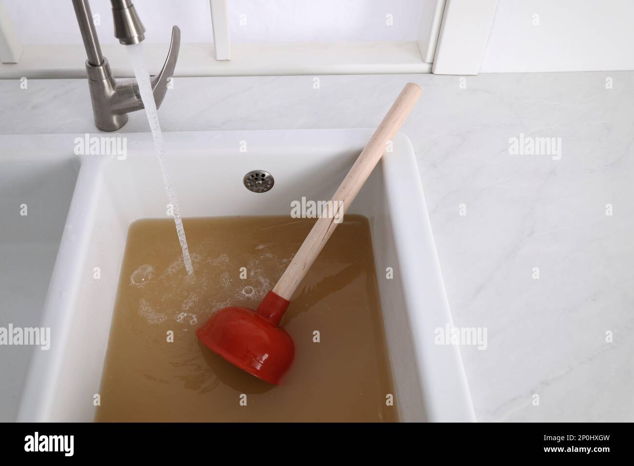 black sink plunger tool in bathroom sink Stock Photo - Alamy