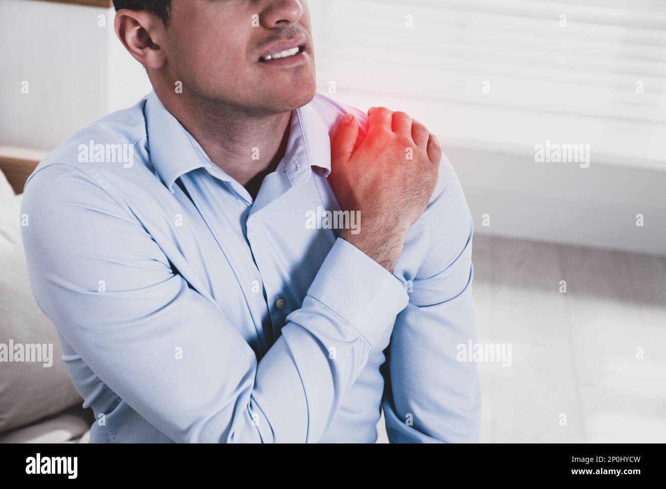 Man suffering from shoulder pain at home, closeup Stock Photo - Alamy