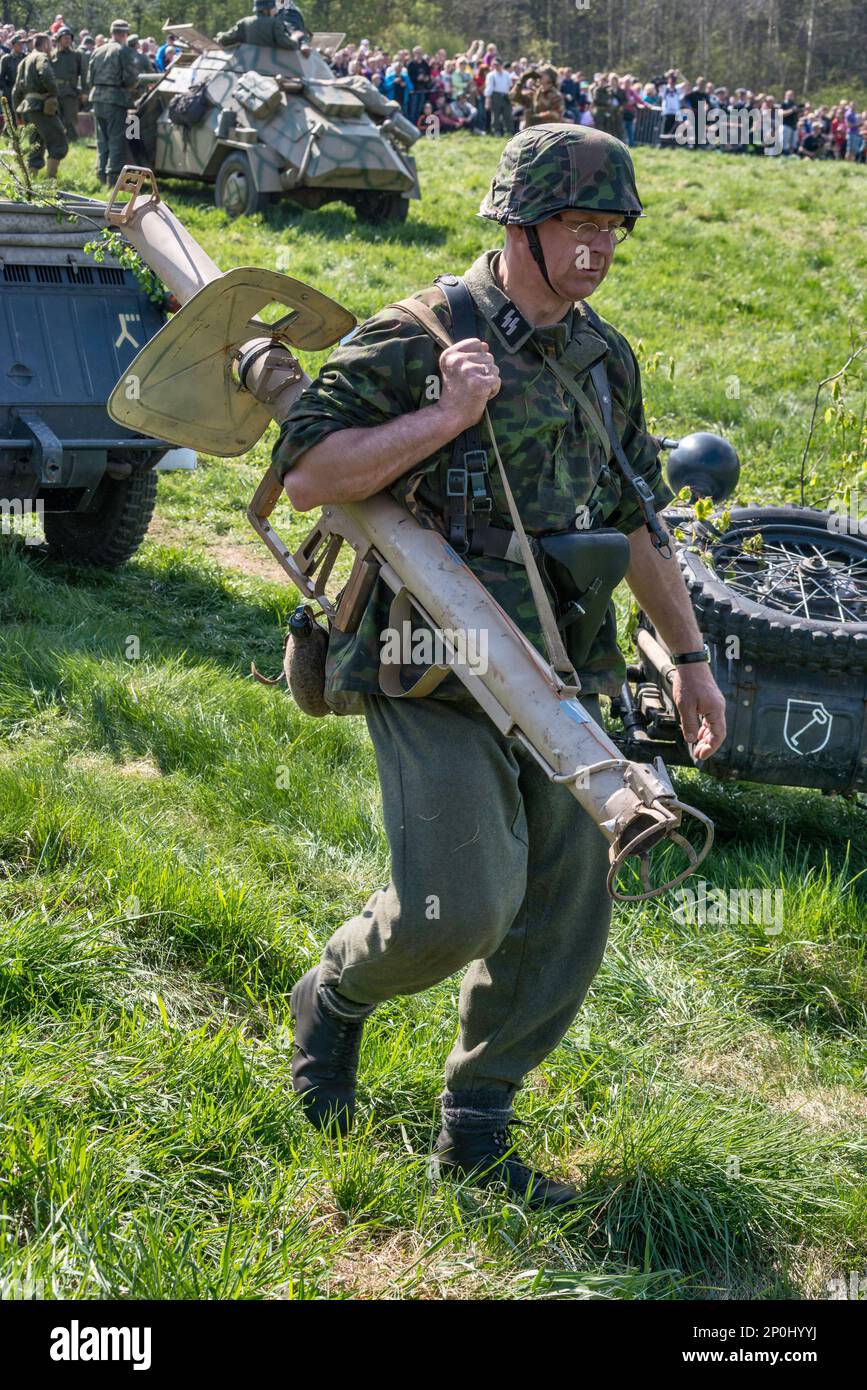 Reenactor in Waffen-SS German uniform, carrying a mortar, at reenactment of WW2 battle, Jelenia Gora, Lower Silesia, Poland Stock Photo