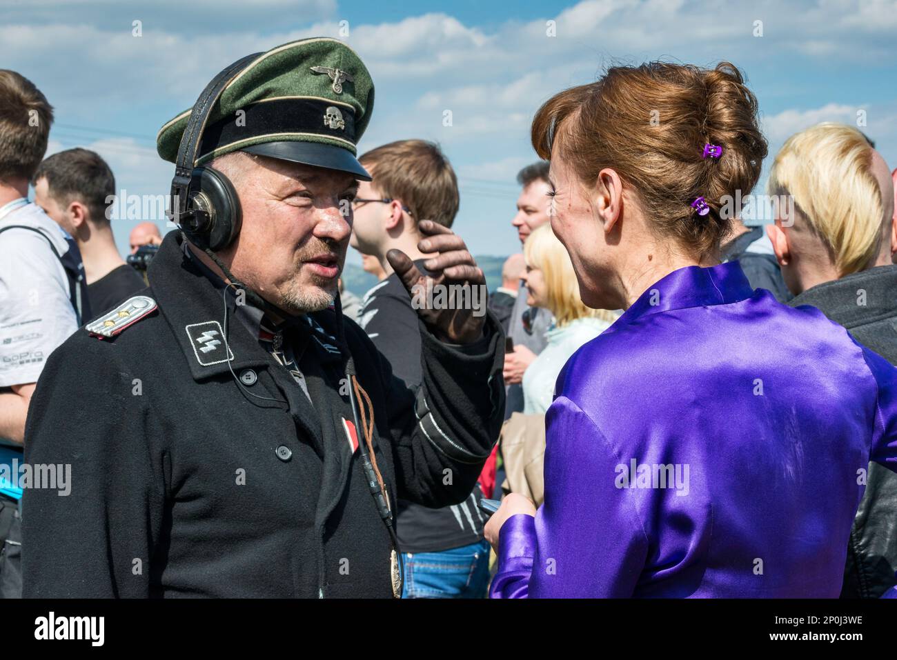 Reenactor in Waffen-SS German uniform, tank driver, woman spectator, talking after reenactment of WW2 battle, Jelenia Gora, Lower Silesia, Poland Stock Photo