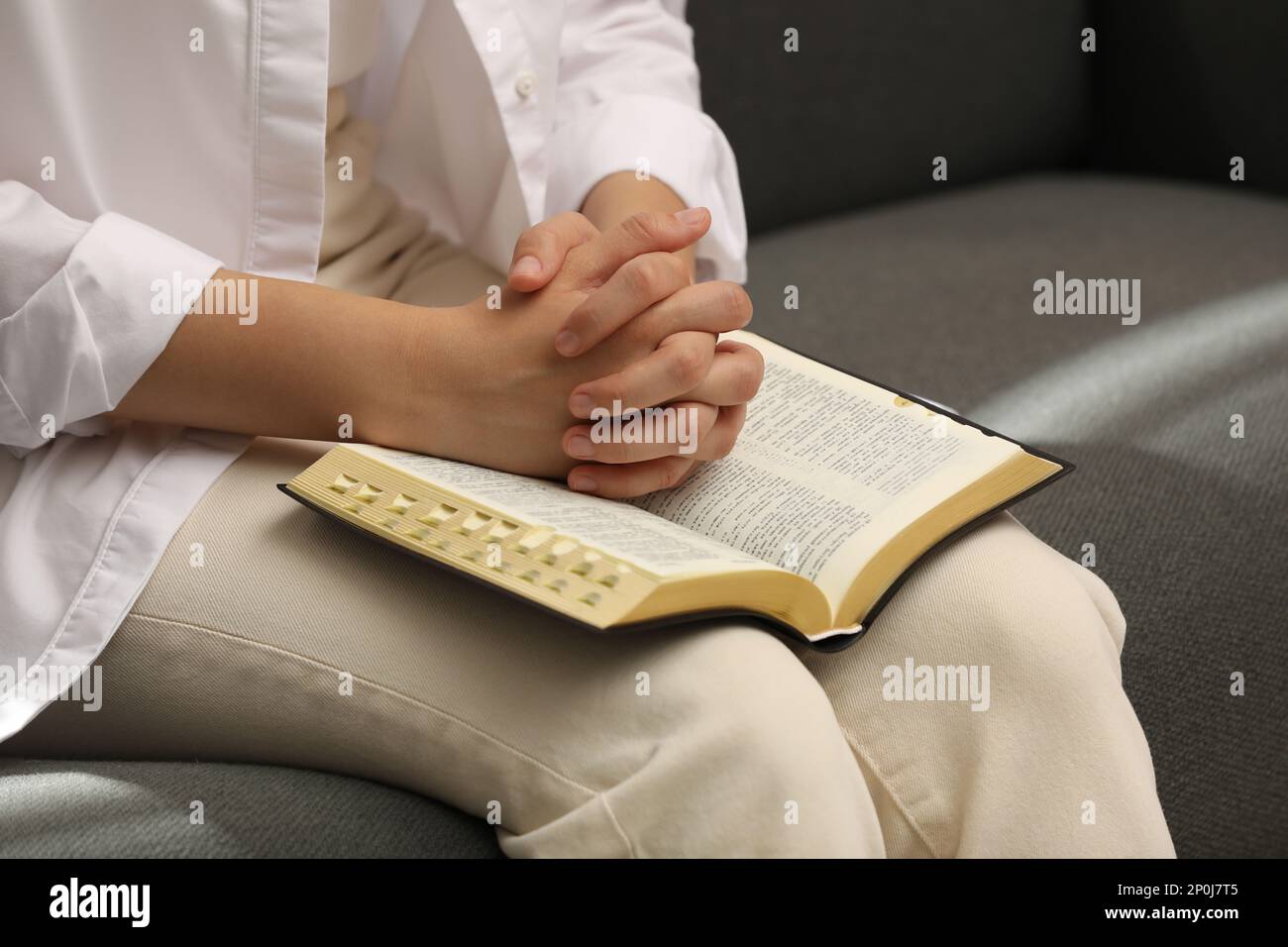 Religious woman praying over Bible indoors, closeup Stock Photo Alamy