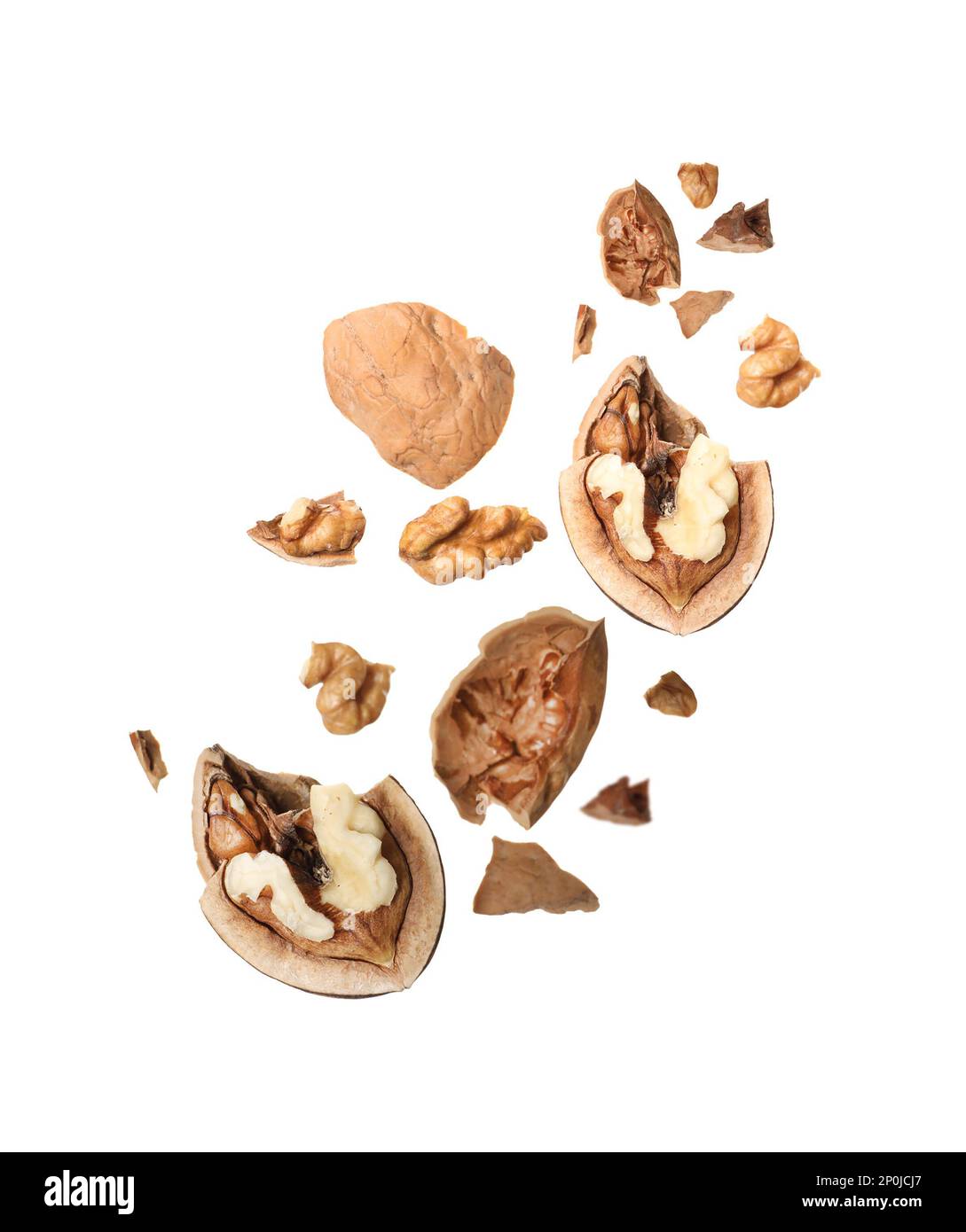 Broken walnut and pieces of shell flying on white background Stock Photo
