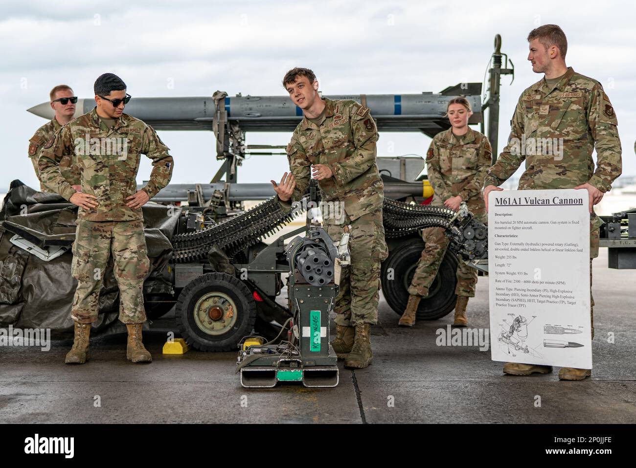Senior Airman Connor Stears, center, 18th Munitions Squadron armament technician, explains the capabilities of a M61A1 Vulcan Cannon machine gun, which are typically attached to fighter aircraft, before the start of Shogun Showdown, a weapons load competition at Kadena Air Base, Japan, Feb. 3, 2023. The 18th MUNS provided information to the audience for the several gun and missile systems that are a part of generating combat-ready aircraft. Stock Photo