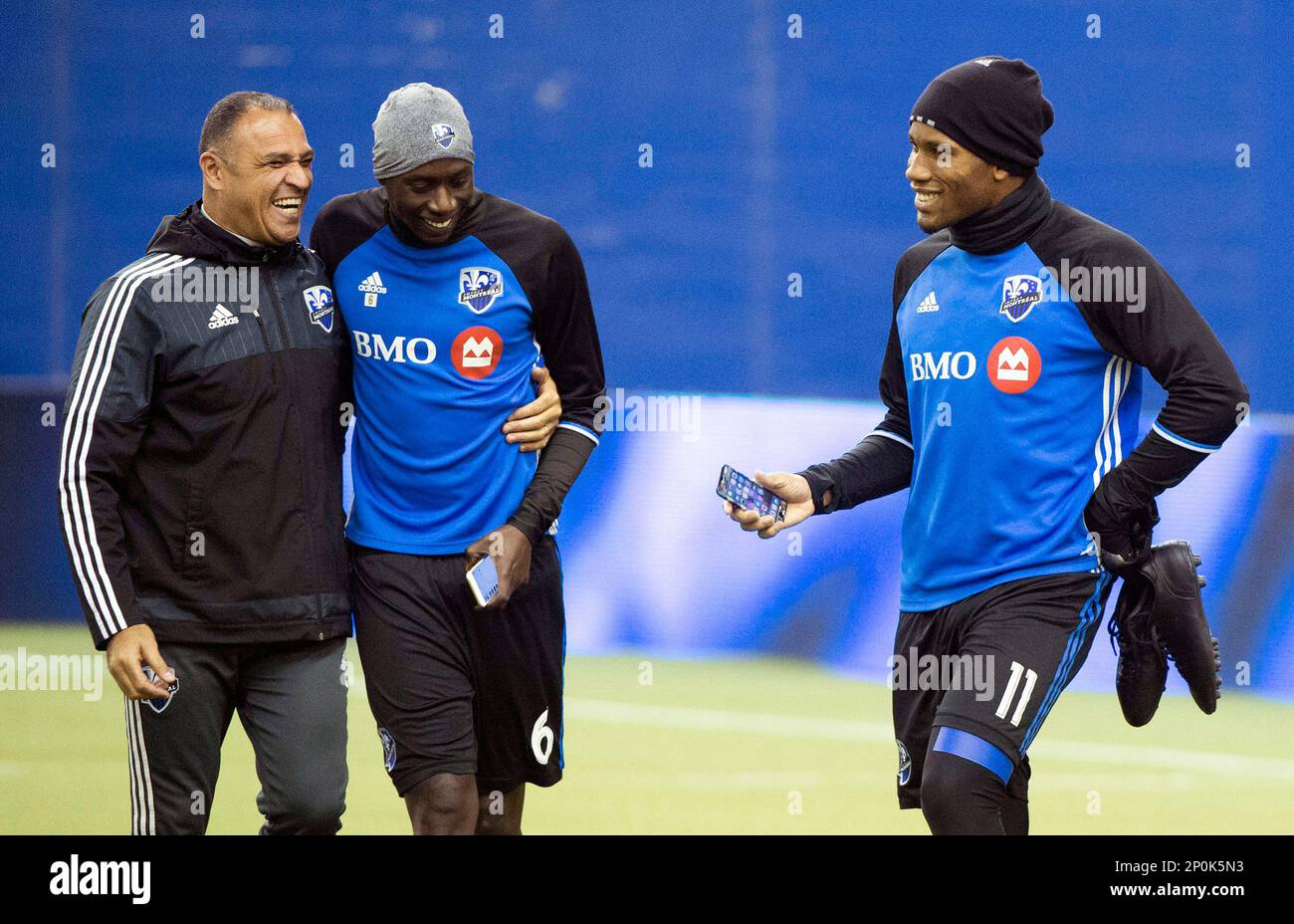 Montreal Impact player Didier Drogba, right, jokes with teammate Hassoun  Camara, center, and goalkeeping coach Youssef Dahha during a training  session in Montreal, Monday, Nov. 21, 2016, ahead of the Eastern Conference
