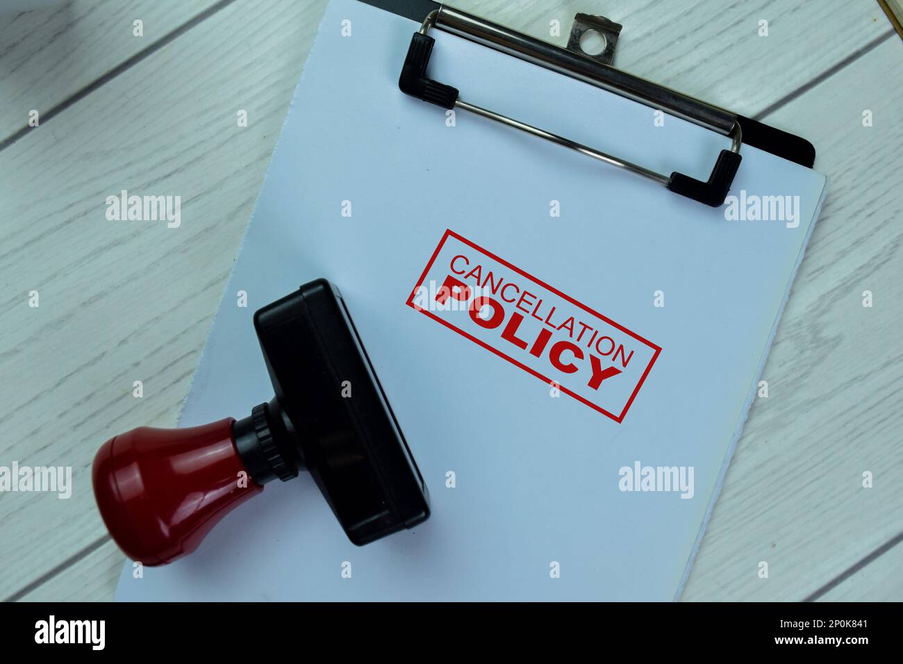 Concept of Red Handle Rubber Stamper and Cancellation Policy text isolated on on Wooden Table. Stock Photo