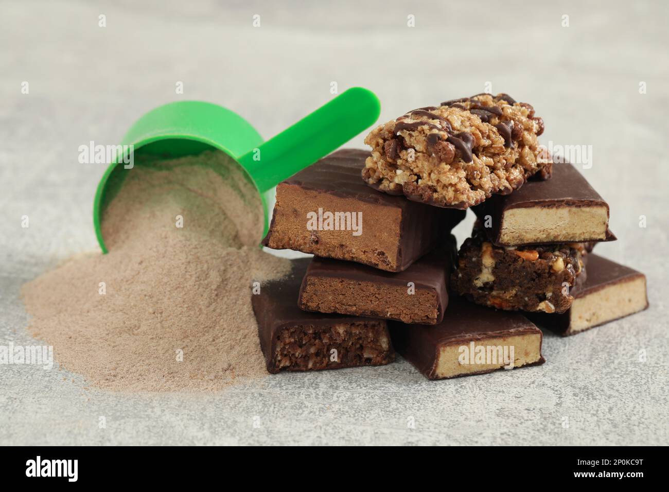 Different energy bars and protein powder on grey table, closeup Stock