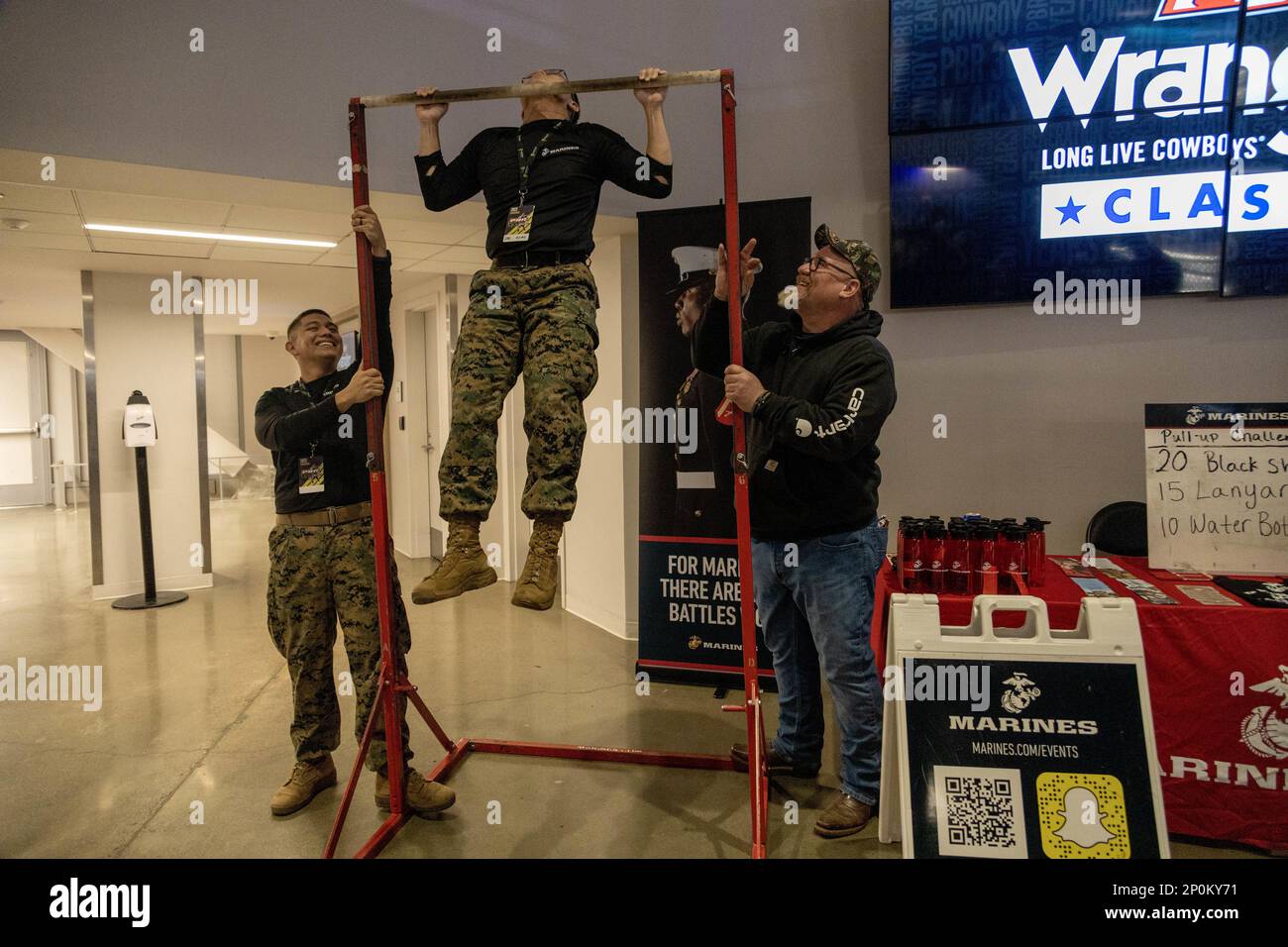 U.S. Marine Corps Staff Sgt. Rodrigo Chavez and Staff Sgt. Ryan S. Saechao, recruiters with Recruiting Sub-Station Fair Oaks, Recruiting Station Sacramento, demonstrate pull-ups during the Professional Bull Riders event at the Golden 1 Center in Sacramento, California on Feb. 3, 2023. Marines with Recruiting Station Sacramento attended the Professional Bull Riders event to interact with the community. Stock Photo