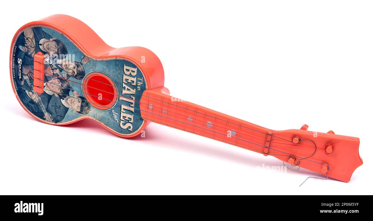 Child's red plastic 1960s Selcol 'Beatles' toy guitar Stock Photo