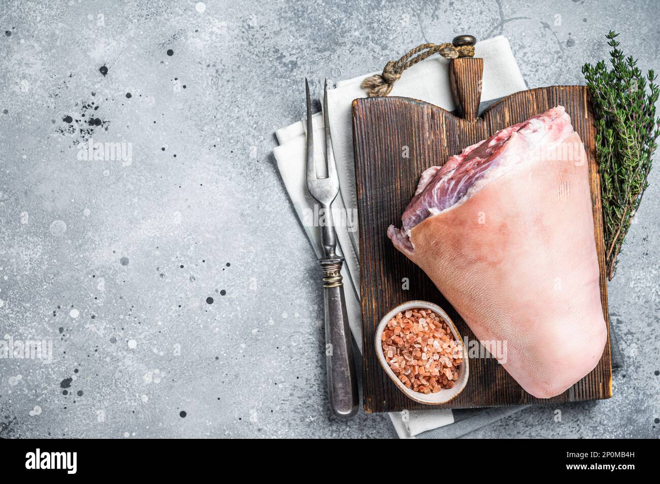 Uncooked Raw pork ham hocks, shanks on a wooden board with spices. Gray