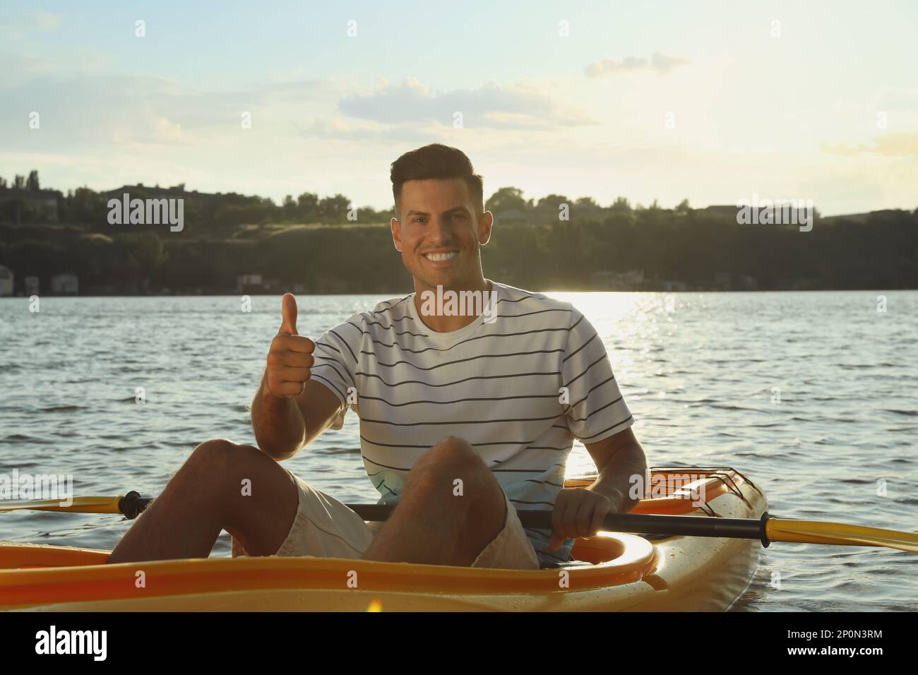 Happy man showing thumb up while kayaking on river. Summer activity Stock Photo