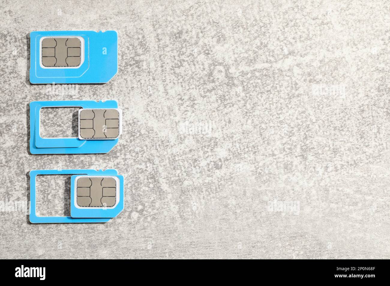 SIM cards on light grey stone background, flat lay. Space for text Stock Photo