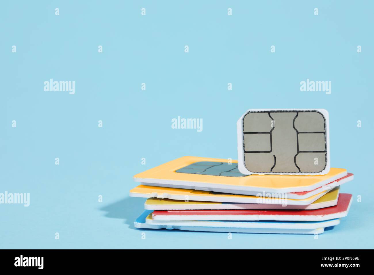 Different SIM cards on light blue background. Space for text Stock Photo