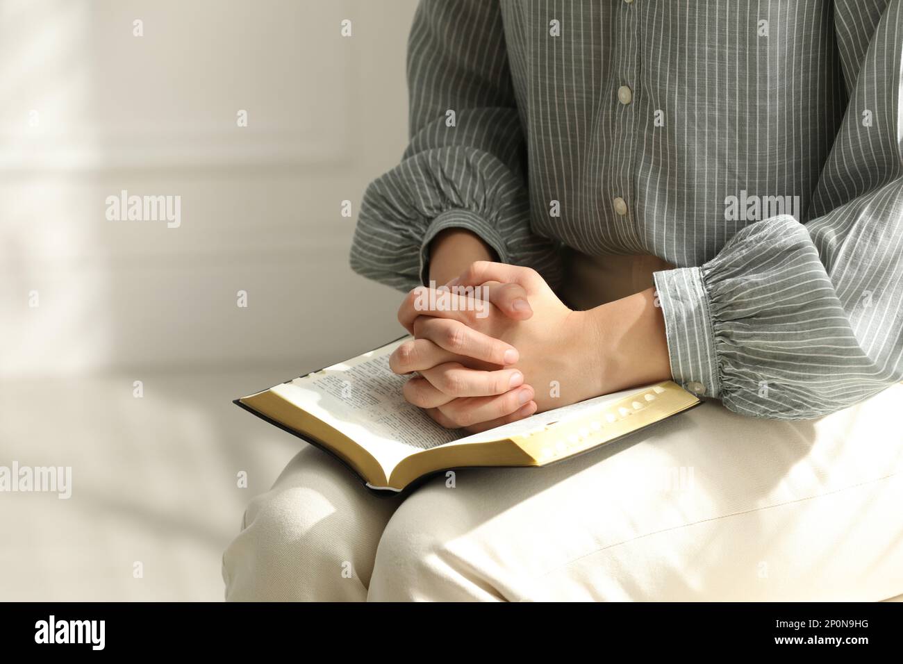 Religious woman praying over Bible indoors, closeup Stock Photo Alamy
