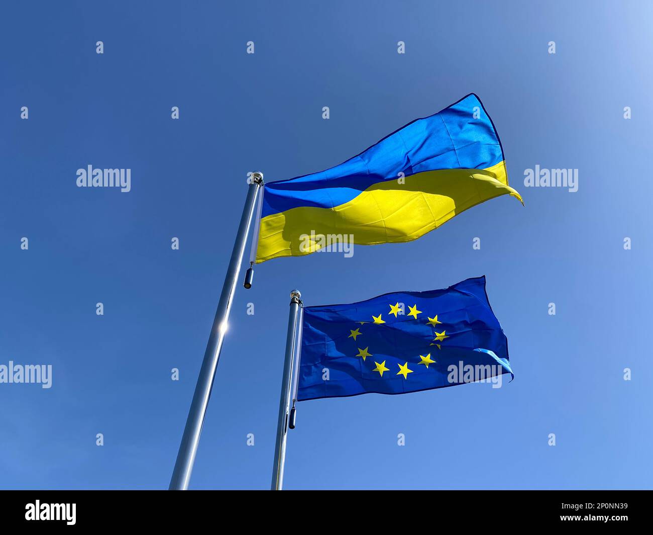 flags of Ukraine and European Union on flagpoles against blue sky Stock ...