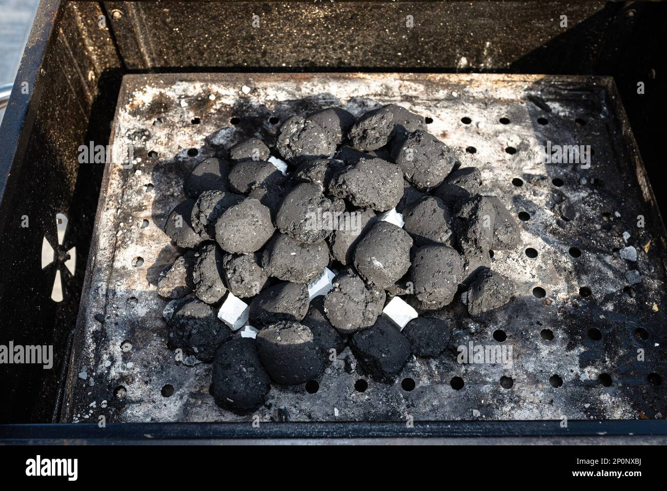 Lighting a home grill with charcoal and white kindling for the grill
