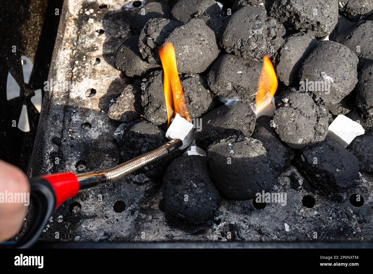 Lighting a home grill with charcoal and white kindling for the grill