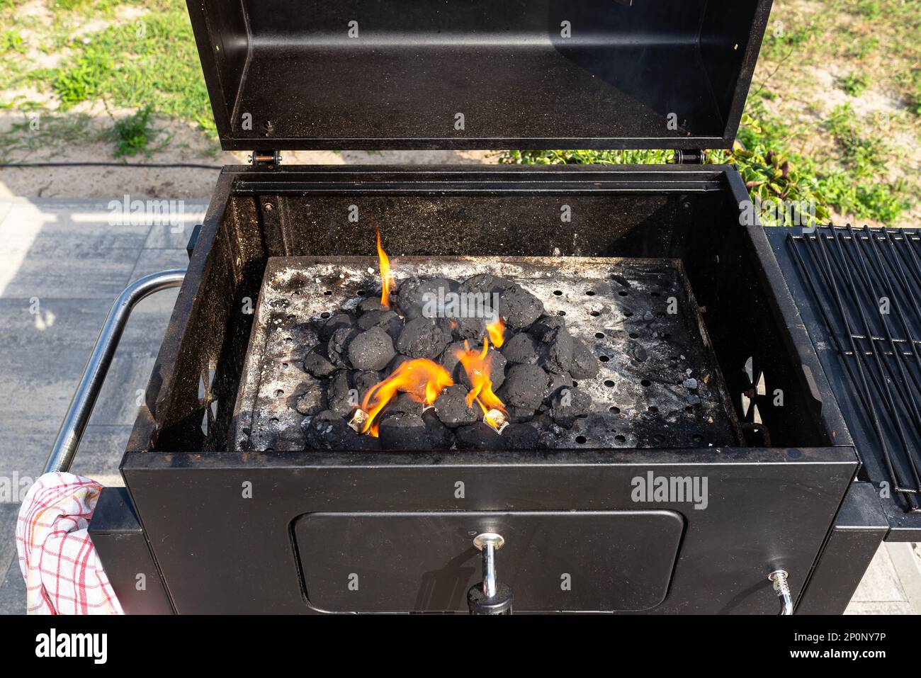 Lighting a home grill with charcoal and white kindling for the grill