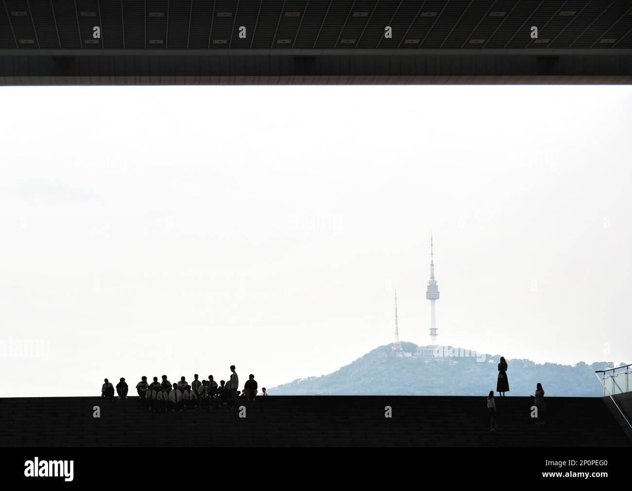 Seoul, South Korea - May 2019: Namsan Seoul N TV Tower view from national musuem of Korea. People silhouette top of the entrance stairs of museum Stock Photo