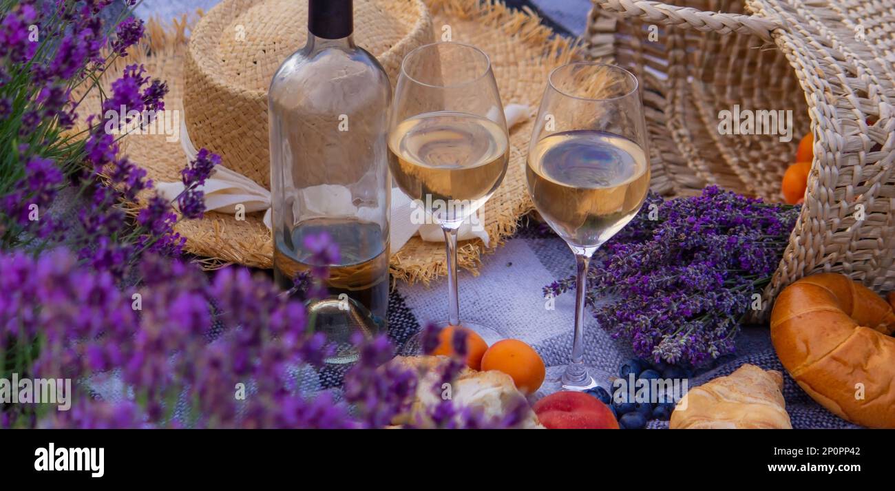 wine, fruits, berries, cheese, glasses picnic in lavender field Selective focus Nature Stock Photo