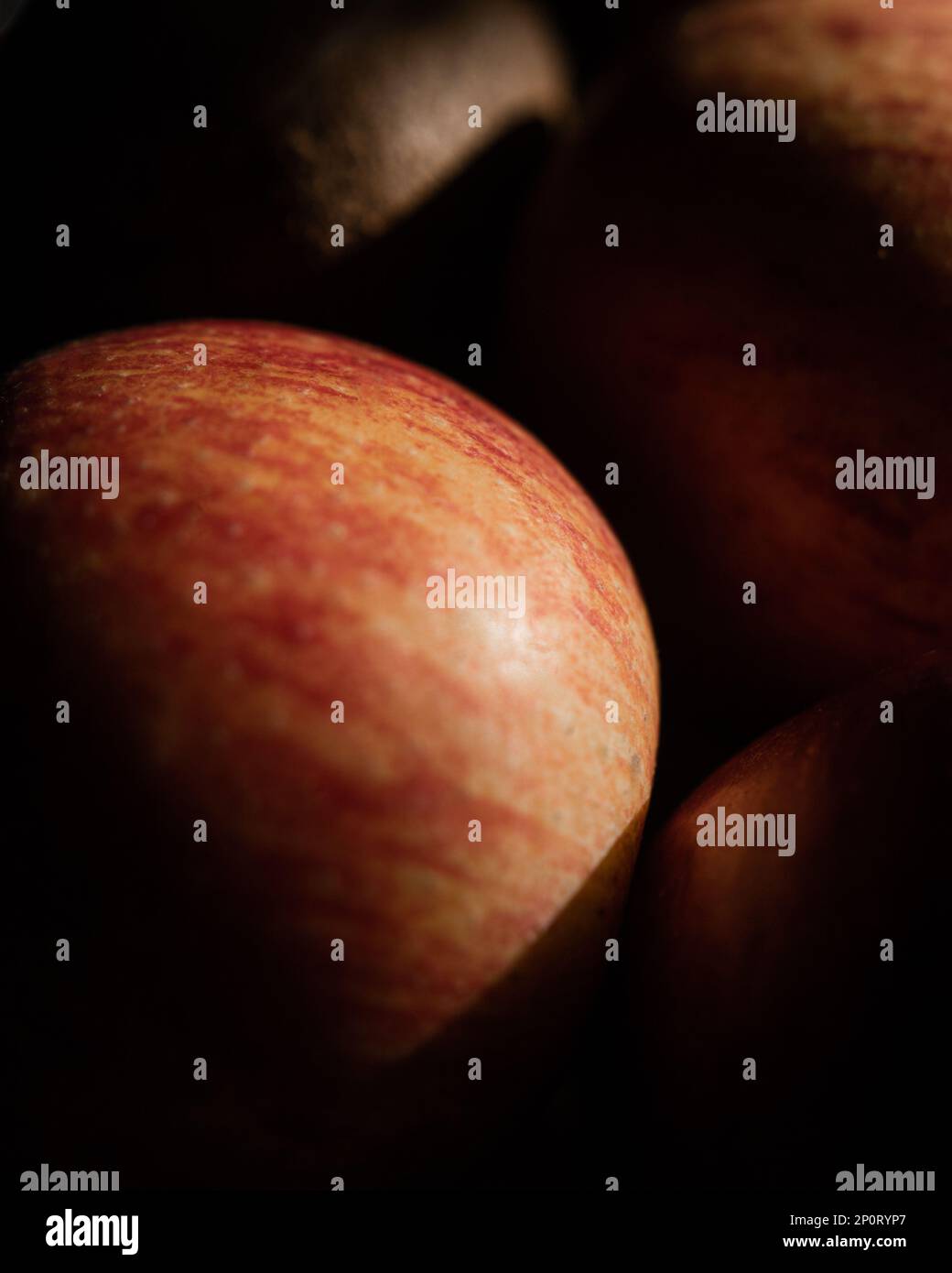 Abstract photograph of apple and other fruits with harsh light and shadow contrast. Macro photography with selective focus. High key and low key Stock Photo