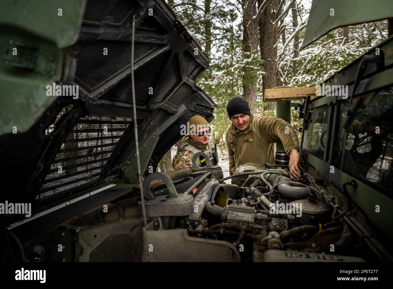 Army Sgt. Josh Harris shows SFC. Jeff Smith, 1-120th Field Artillery Regiment, the issue with the engine on the M1151 Humvee during Northern Strike 23-1, Jan. 23, 2023, at Camp Grayling, Mich. Units that participate in Northern Strike’s winter iteration build readiness by conducting joint, cold-weather training designed to meet objectives of the Department of Defense’s Arctic Strategy. Stock Photo