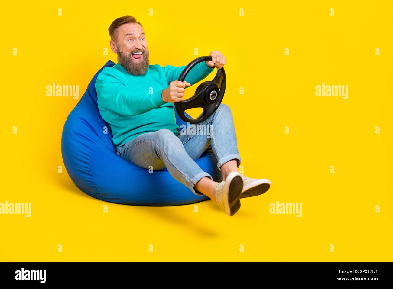 Full body photo of nice grandpa beanbag play car simulator steering