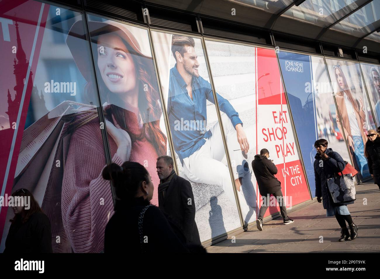 Passers-by and a new retail space opportunity hoarding in the City of London, the capital's financial district, on 2nd March 2023, in London, England. Stock Photo